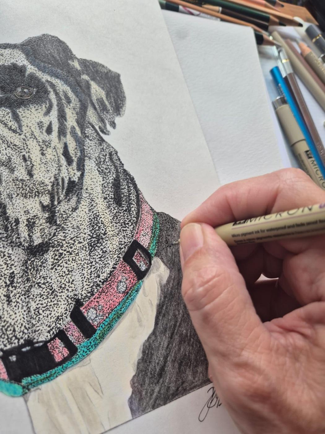 Stippling the Great Dane's coat with a fine ink pen, coloured pencils beside the paper